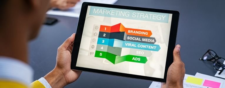 A person holding a tablet displaying a digital marketing strategy presentation.