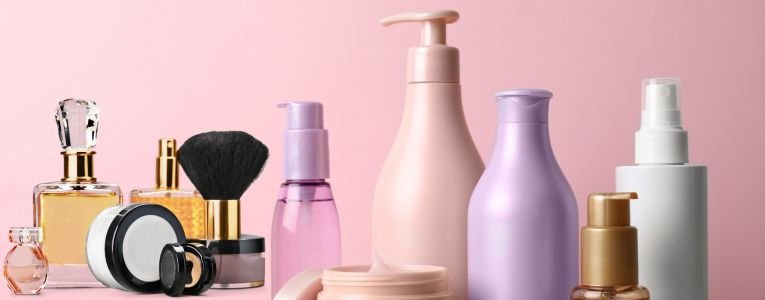 Assorted hair care products arranged on a wooden table, unlabeled beauty items.