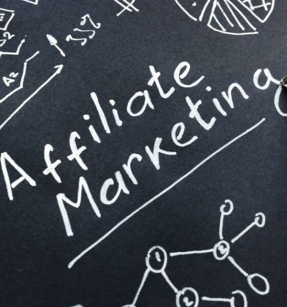 Man is writing Affiliate marketing on a black surface. (high ticket affiliate marketing)