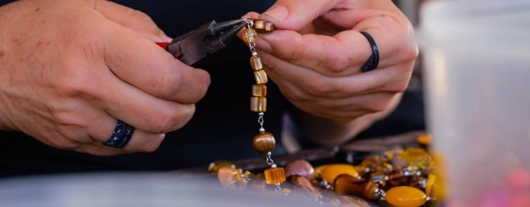 Closeup of Person Making Handmade Jewelry with Beads