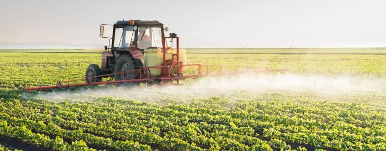 Tractor spraying soybean