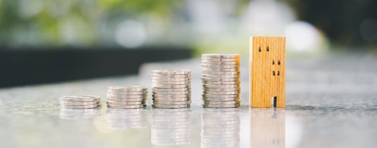 Wood house and row of coin money on wood table and , selective focus, Planning to buy property. Choose what's the best. A symbol for construction ,ecology, loan concepts