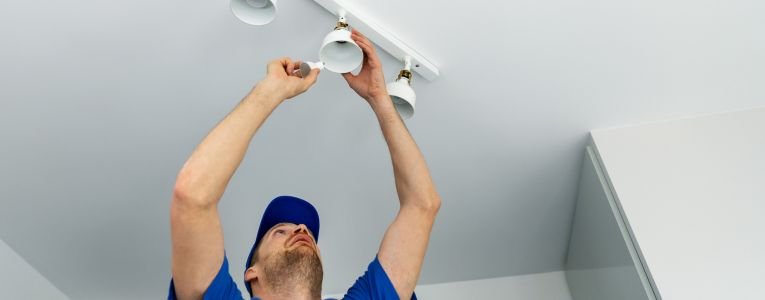 electrician installing led light bulbs in ceiling lamp